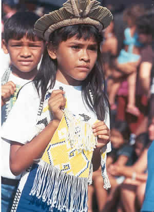 A cara de Parintins: menina usando cocar e adereço trabalhado em material artesanal pela escola de arte do Caprichoso